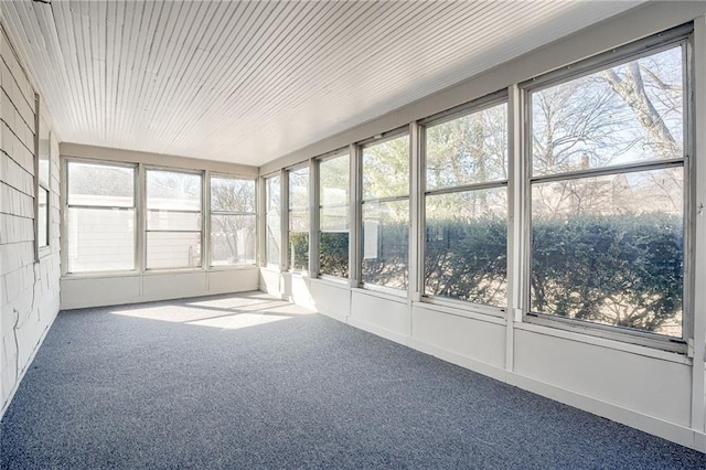 unfurnished sunroom featuring wooden ceiling and a wealth of natural light