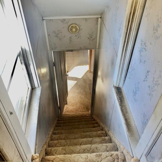 staircase featuring wallpapered walls