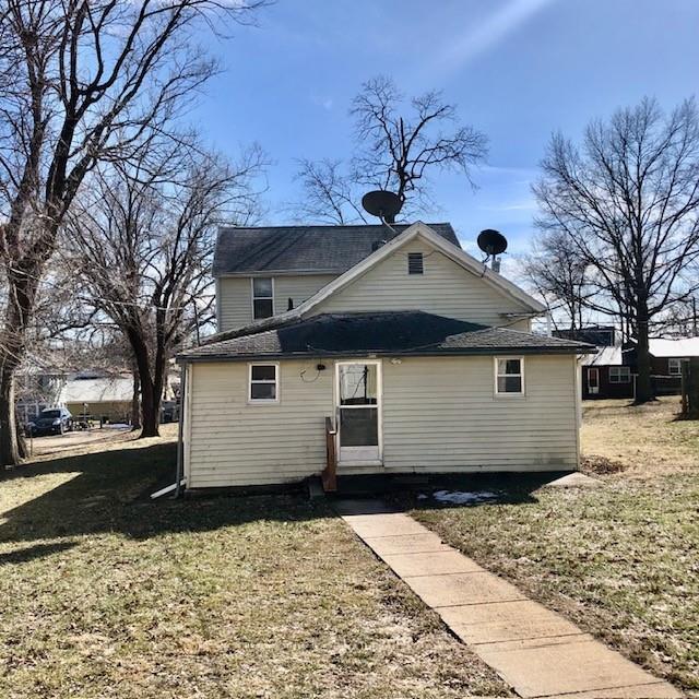 back of property featuring a lawn