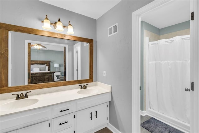 ensuite bathroom featuring double vanity, a shower with curtain, visible vents, and a sink