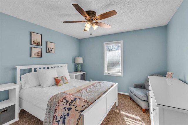 carpeted bedroom with ceiling fan, baseboards, and a textured ceiling