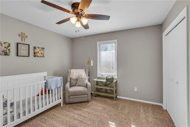 carpeted bedroom featuring a ceiling fan, a nursery area, baseboards, and a closet