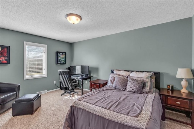 bedroom featuring visible vents, a textured ceiling, baseboards, and carpet floors