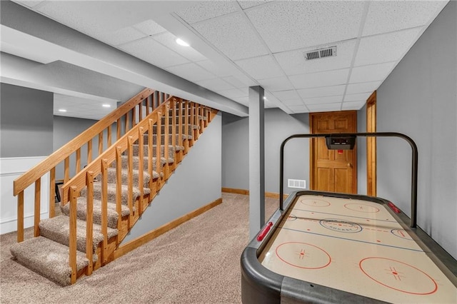 recreation room with carpet, visible vents, a drop ceiling, and baseboards