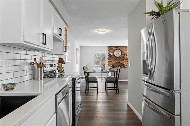 kitchen featuring dark wood finished floors, stainless steel appliances, tasteful backsplash, white cabinetry, and light stone countertops