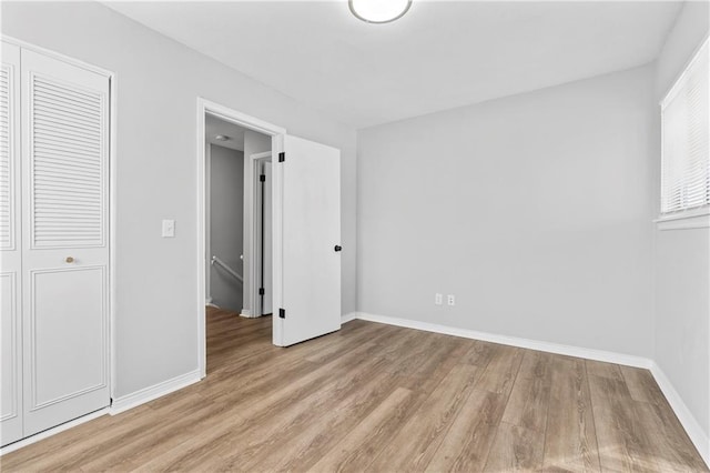 unfurnished bedroom featuring light wood-style flooring and baseboards