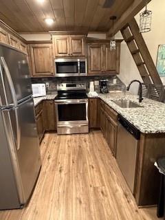 kitchen featuring wooden ceiling, light wood-style flooring, appliances with stainless steel finishes, and a sink