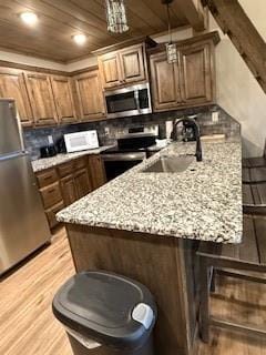 kitchen featuring appliances with stainless steel finishes, a sink, and a kitchen breakfast bar