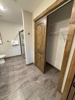 bathroom featuring a shower stall and toilet