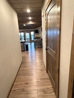 hallway featuring baseboards and light wood-style floors