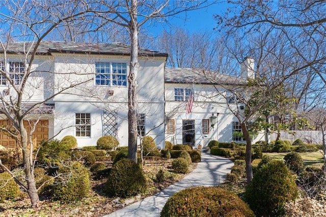 view of front of home featuring a chimney and stucco siding