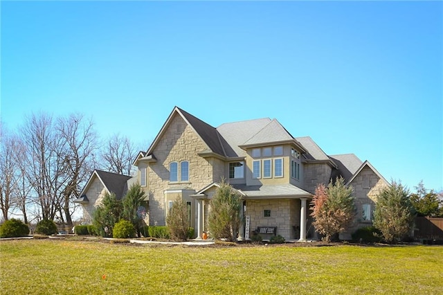 craftsman-style home featuring stone siding and a front yard