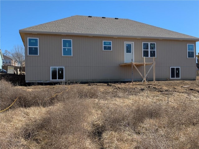 rear view of house with a shingled roof