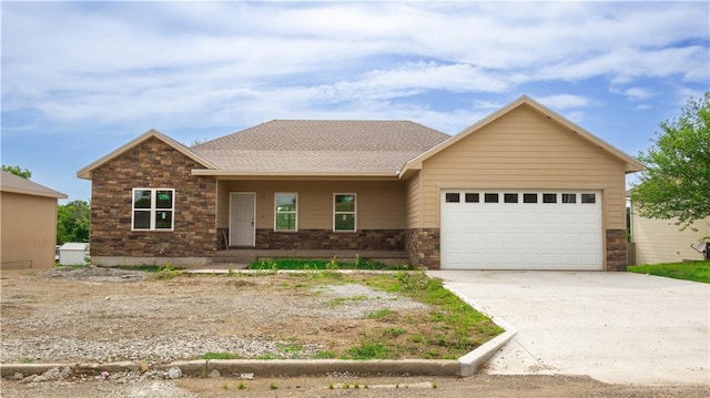 1107 Charles St, Knob Noster, MO 65336 - view of front of home with an attached garage, stone siding, concrete driveway, and covered porch