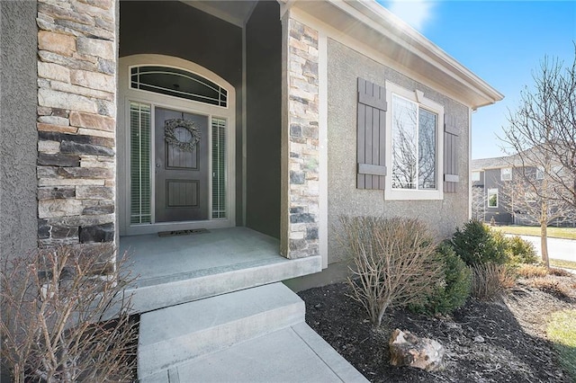 property entrance featuring stone siding and stucco siding