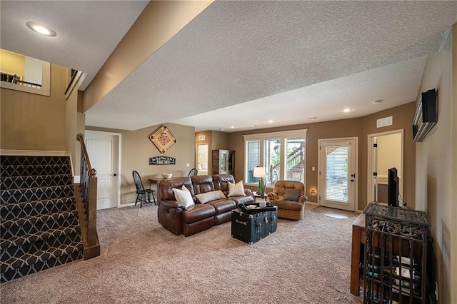 carpeted living area with recessed lighting, baseboards, stairway, and a textured ceiling