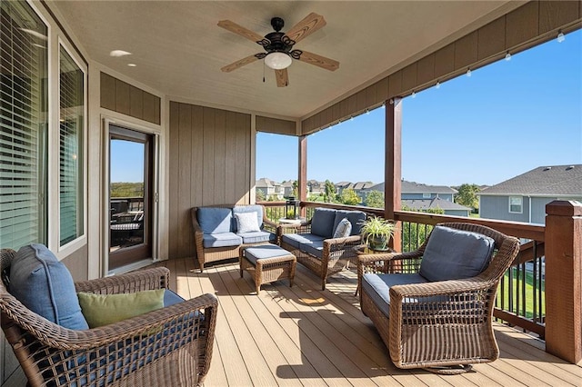 wooden terrace featuring a residential view, ceiling fan, and an outdoor living space