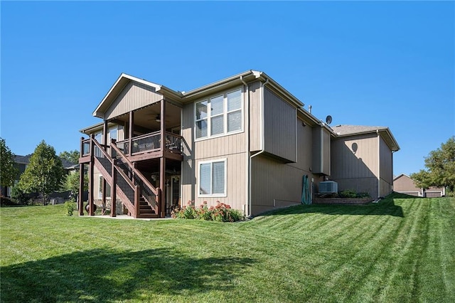 rear view of house with cooling unit, a lawn, stairway, and a ceiling fan