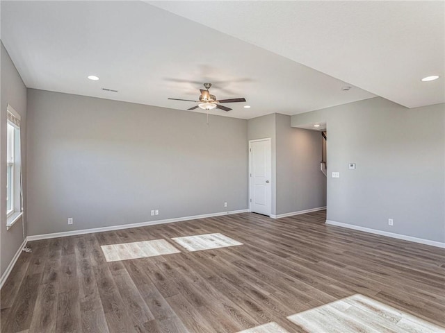 empty room featuring ceiling fan, baseboards, dark wood-type flooring, and recessed lighting