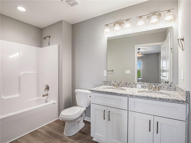 full bath with wood finished floors, tub / shower combination, a sink, and visible vents