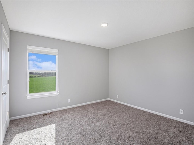 empty room featuring carpet and baseboards