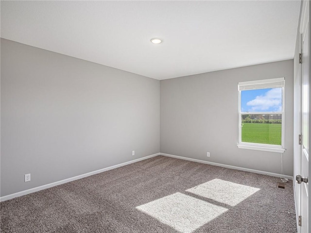 carpeted spare room with visible vents and baseboards