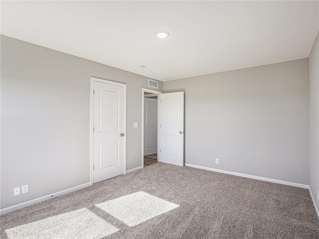 unfurnished bedroom with carpet flooring, visible vents, and baseboards