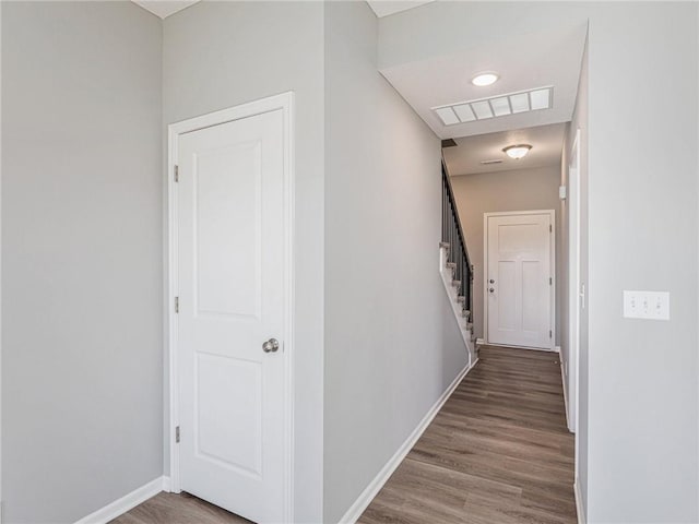 corridor featuring stairway, wood finished floors, visible vents, and baseboards