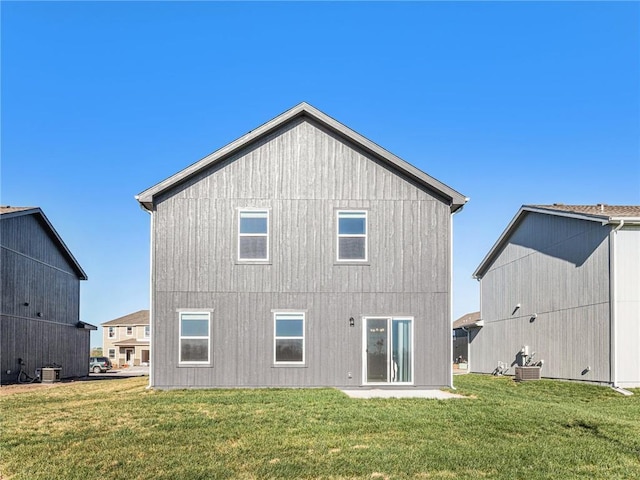 rear view of property with central AC and a lawn