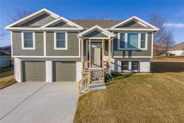 raised ranch with a garage, driveway, and a front lawn