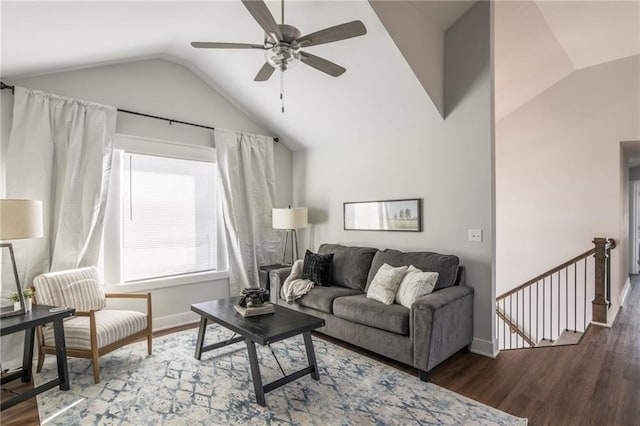 living area featuring lofted ceiling, baseboards, a ceiling fan, and dark wood-type flooring