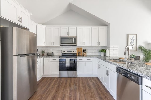 kitchen with dark wood-type flooring, lofted ceiling, stainless steel appliances, white cabinetry, and a sink