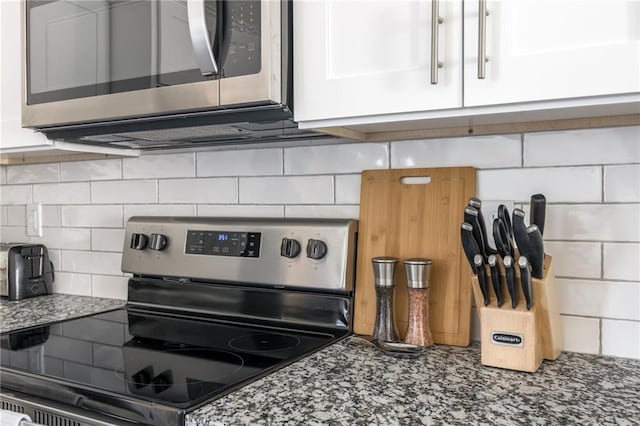 kitchen with stone countertops, tasteful backsplash, appliances with stainless steel finishes, and white cabinets