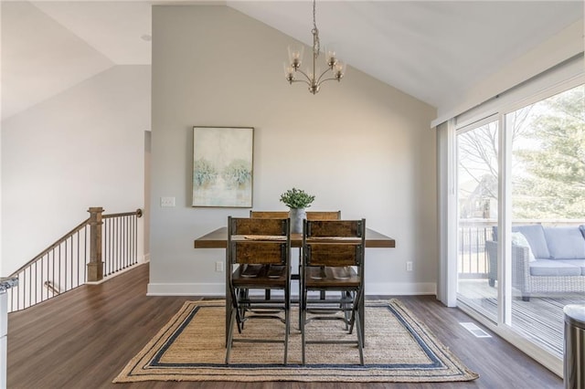 dining room featuring an inviting chandelier, vaulted ceiling, wood finished floors, and baseboards