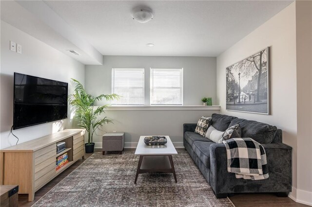 living area with baseboards and wood finished floors