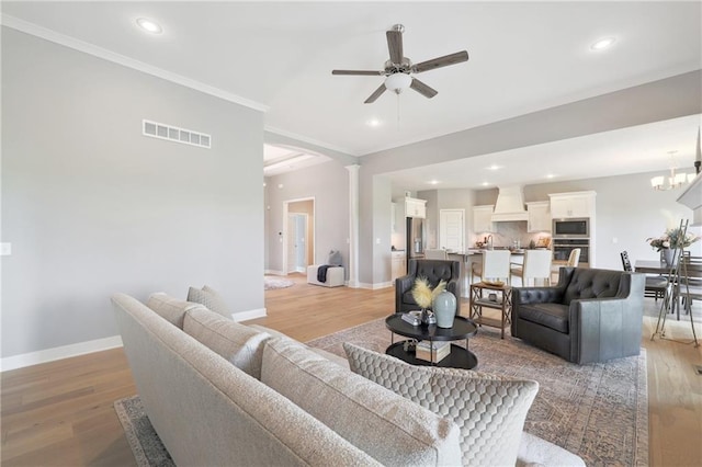 living area featuring light wood finished floors, baseboards, and visible vents