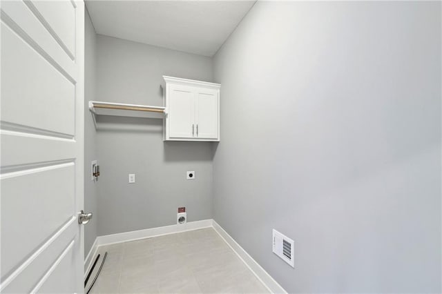 washroom featuring hookup for an electric dryer, cabinet space, visible vents, and baseboards