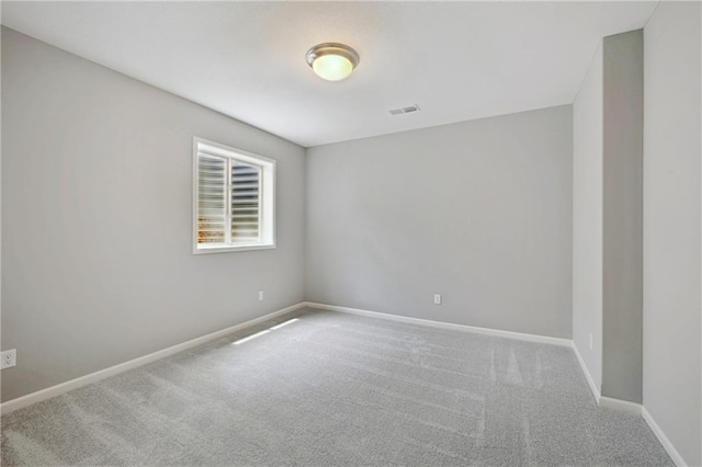 spare room featuring visible vents, baseboards, and carpet flooring