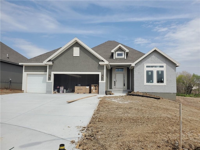 view of front of property with a garage, driveway, a shingled roof, and stucco siding