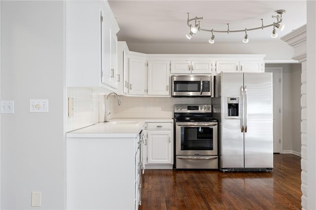 kitchen with dark wood finished floors, decorative backsplash, appliances with stainless steel finishes, white cabinetry, and a sink