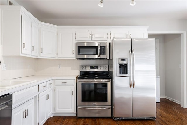 kitchen with dark wood finished floors, backsplash, appliances with stainless steel finishes, and white cabinets