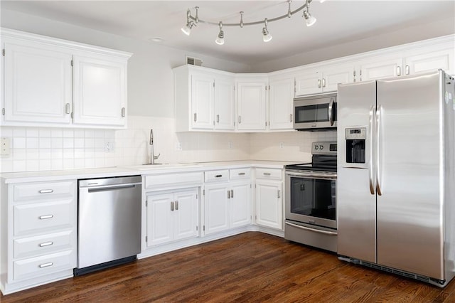 kitchen with visible vents, dark wood-style floors, white cabinets, stainless steel appliances, and a sink