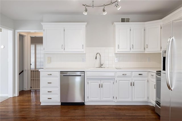 kitchen with visible vents, a sink, dark wood-type flooring, appliances with stainless steel finishes, and white cabinetry