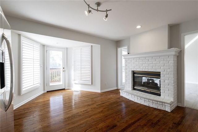 unfurnished living room with recessed lighting, baseboards, wood finished floors, and a fireplace