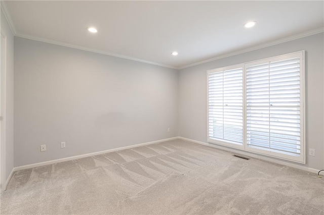 spare room featuring recessed lighting, light colored carpet, visible vents, and ornamental molding