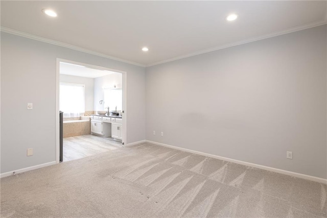 spare room with recessed lighting, light colored carpet, crown molding, and baseboards