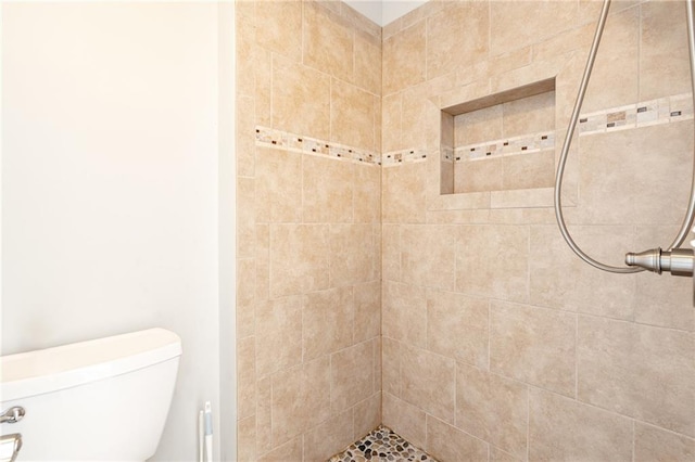 bathroom with toilet and tiled shower