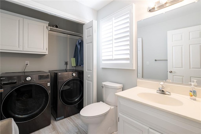 bathroom featuring washer and clothes dryer, toilet, and vanity