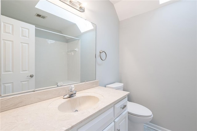 bathroom with vanity, visible vents, vaulted ceiling, walk in shower, and toilet