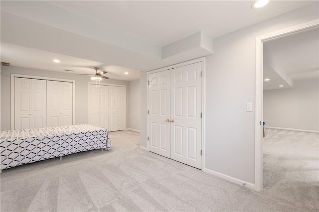 unfurnished bedroom with recessed lighting, baseboards, carpet floors, and multiple closets